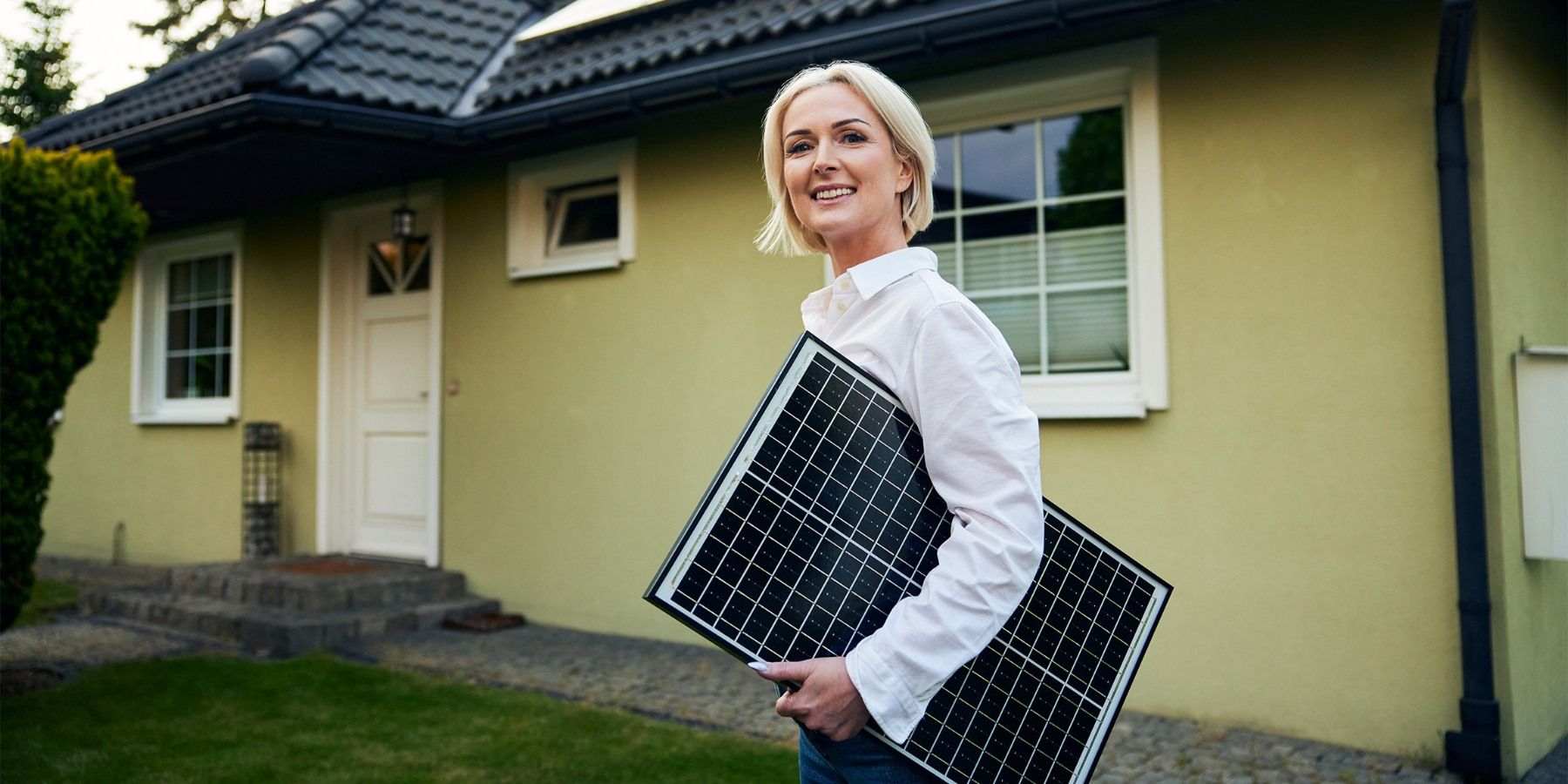 Homeowner holding solar panel outside home Energy View