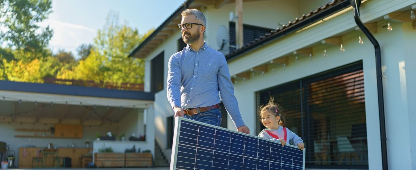 Homeowner and daughter holding solar panels Energy View