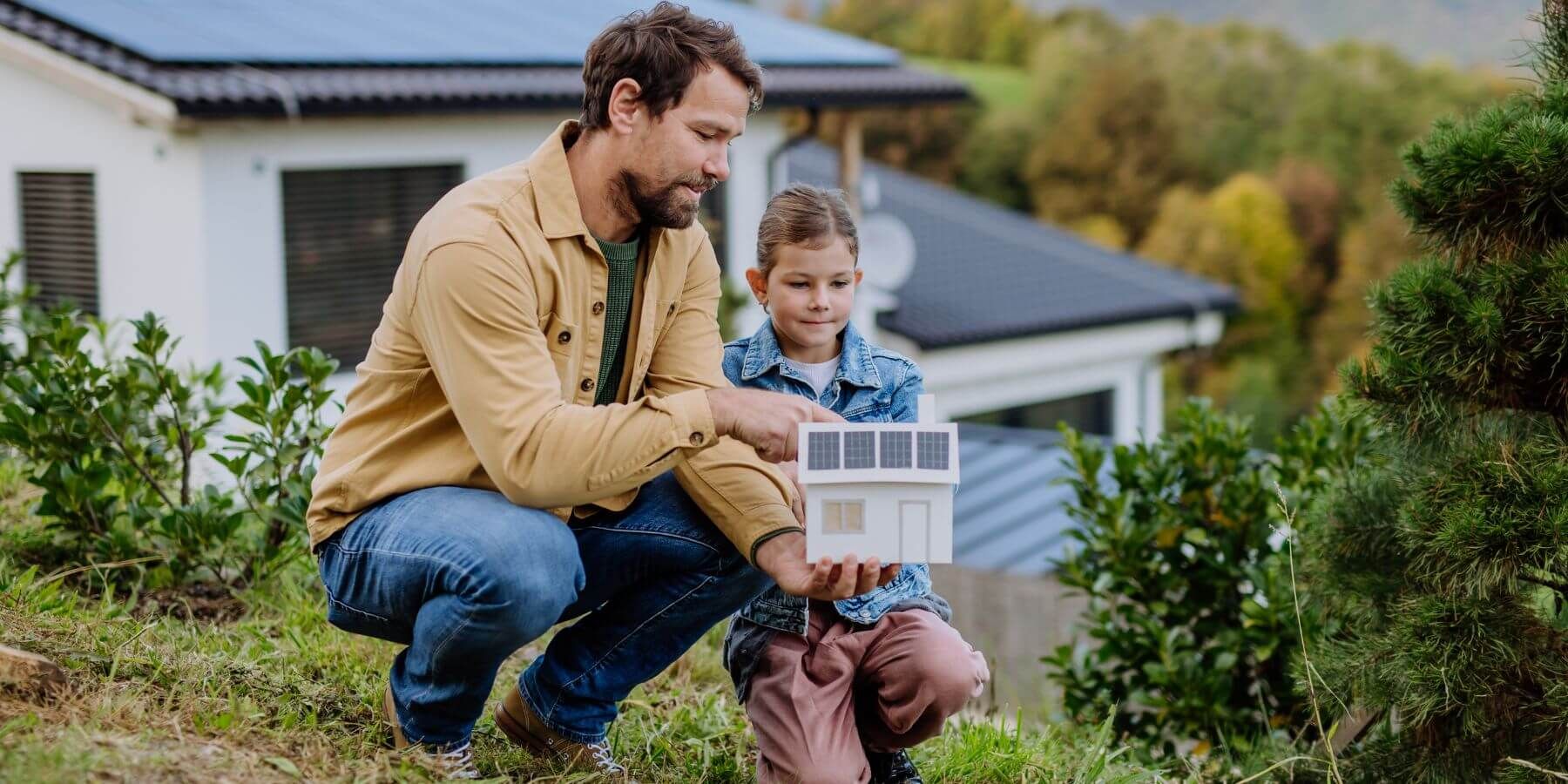 Homeowner showing daughter model of home with solar panels on it