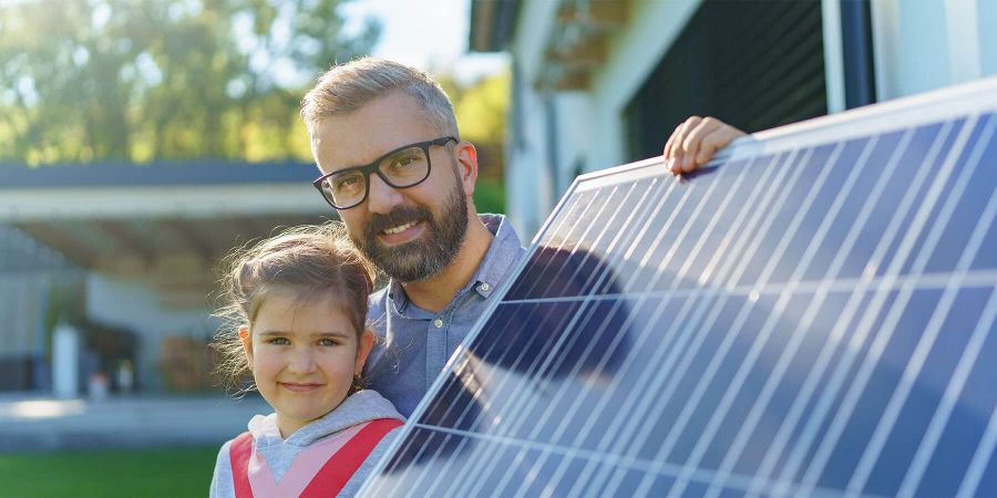 Homeowner and daughter holding up solar panel outside Energy View